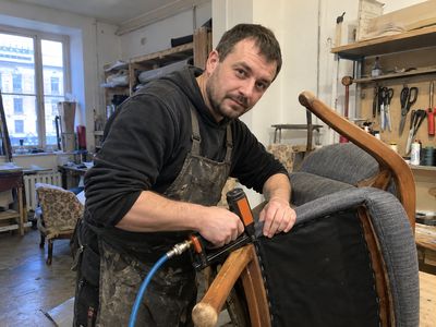 Обивщик за работой в мебельной мастерской
